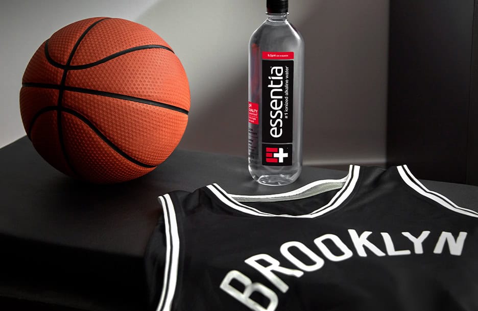 Essentia Water bottle next to basketball and basketball jersey